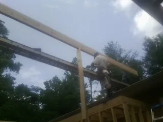 Carpenter setting a ridge beam over a new addition frame — Ice Dam Removal by Roofing Brothers in Rainier